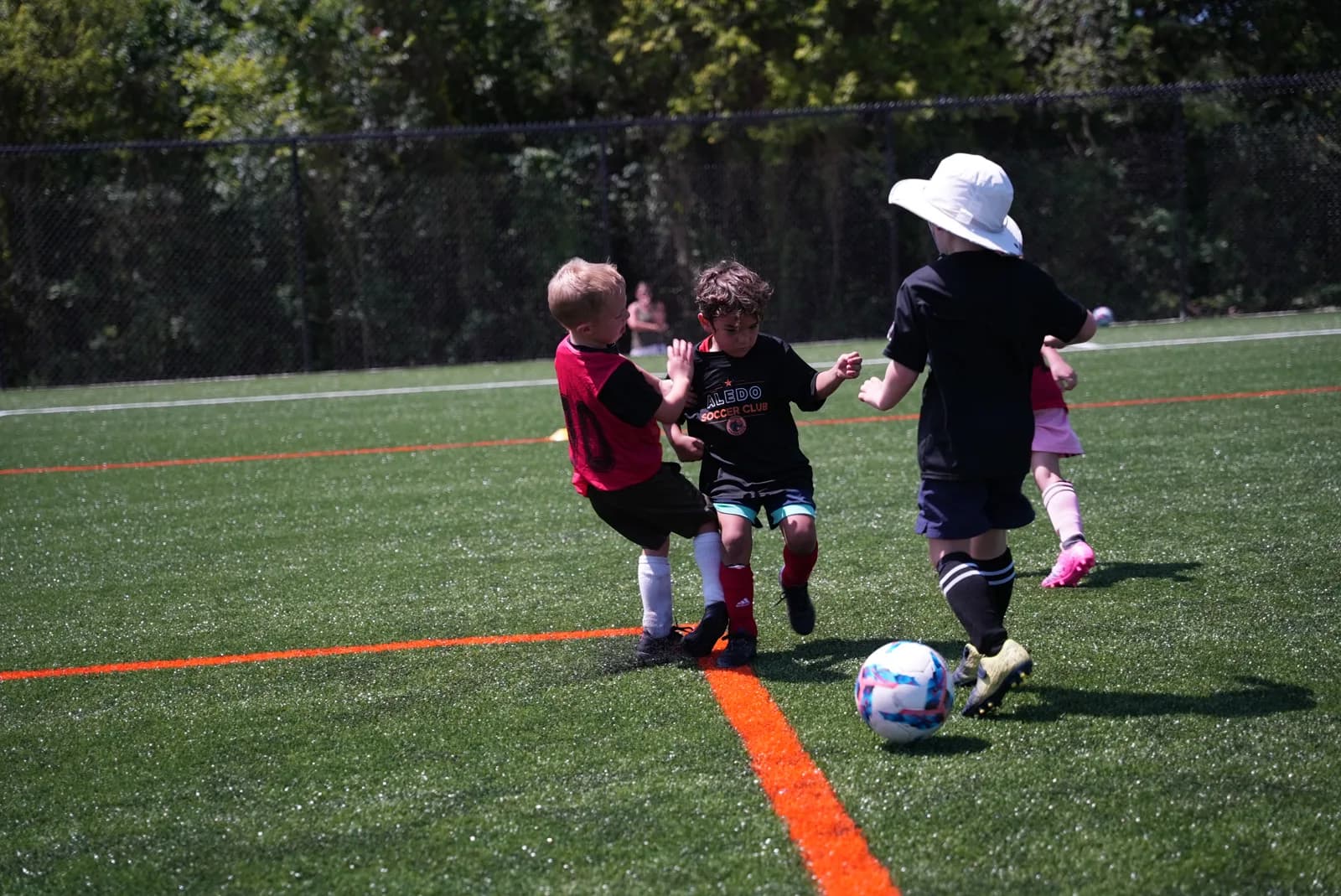 Little Aledos players ages 4–6 battling for the ball on game day at The Stable